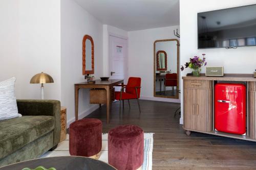 a living room with a couch and a red refrigerator at Virgin Hotels London - Shoreditch in London