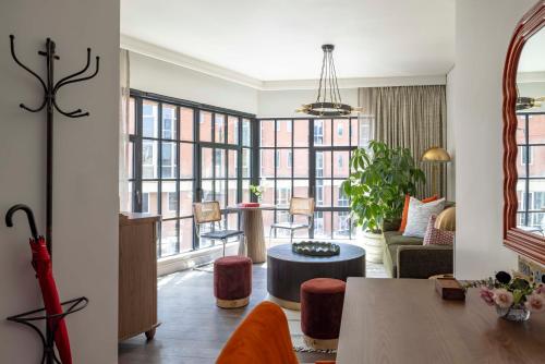 a living room with a table and some windows at Virgin Hotels London - Shoreditch in London