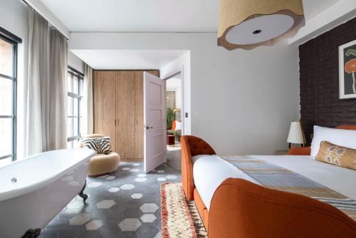 a bedroom with a bed and a tub and a sink at Virgin Hotels London - Shoreditch in London