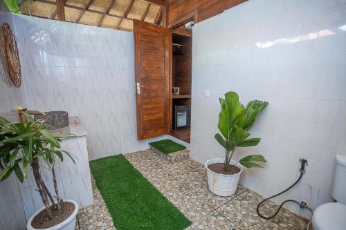 a bathroom with a toilet and plants in it at Alinn Villas in Nusa Lembongan