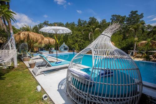a bird cage sitting next to a swimming pool at Alinn Villas in Nusa Lembongan