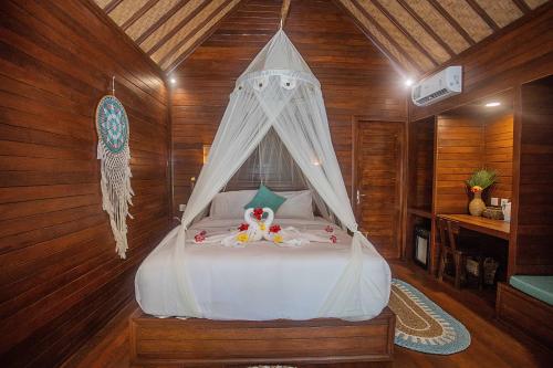 a bedroom with a white bed with a canopy at Alinn Villas in Nusa Lembongan