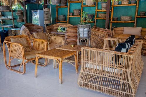 a room with wicker chairs and tables and chairs at Alinn Villas in Nusa Lembongan