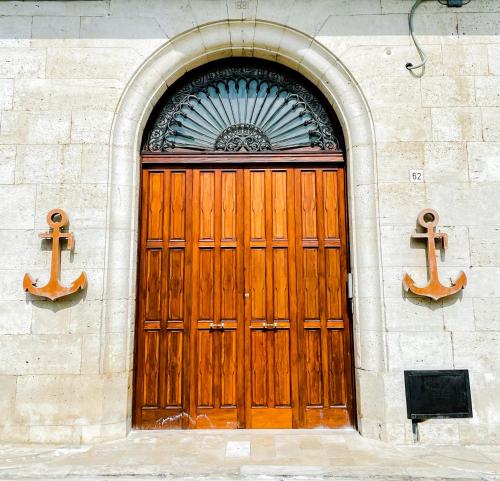 een houten deur op een gebouw met twee ankers bij L'Ancora appartamenti 5 in Giovinazzo