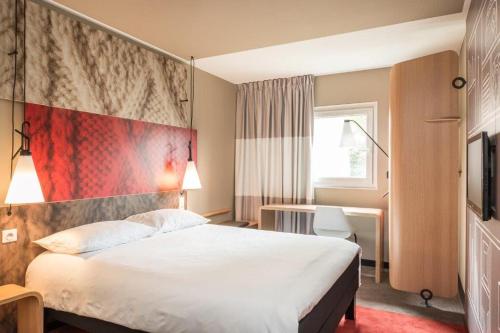 a hotel room with a large bed and a desk at Ibis Hamburg City in Hamburg