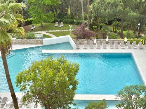 une grande piscine avec des chaises et un palmier dans l'établissement 98 m2 - Beautiful Panoramic Sea View of Cannes, à Vallauris