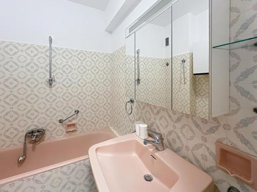 La salle de bains est pourvue d'un lavabo rose et d'une douche. dans l'établissement 98 m2 - Beautiful Panoramic Sea View of Cannes, à Vallauris