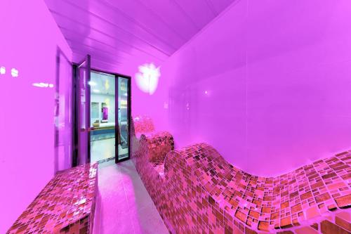 a purple room with pink chairs in a room at Hotel Zensual in Bogotá