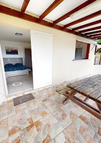 a room with a bed and a table in it at Studio charmant à Rivière-Pilote avec piscine in Rivière-Pilote