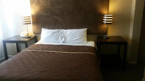 a hotel room with a bed and two night stands at The Gold Lodge in Sonora