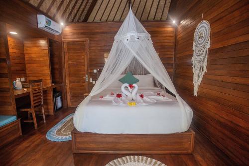 a bedroom with a bed with a canopy at Alinn Villas in Nusa Lembongan