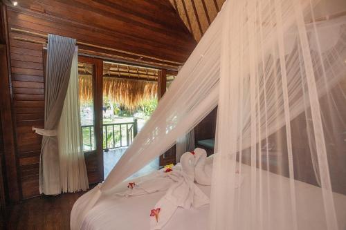 a bedroom with a bed with a mosquito net at Alinn Villas in Nusa Lembongan