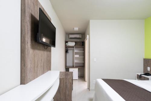 a bedroom with a tv on a wall at Pousada Quinta da Baleeira in Penha