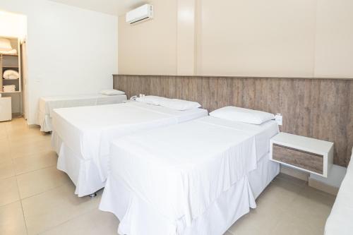 a room with two beds with white sheets at Pousada Quinta da Baleeira in Penha