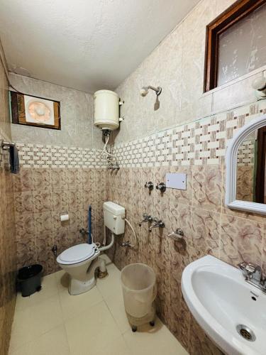 a bathroom with a toilet and a sink at Sharda House in Manāli