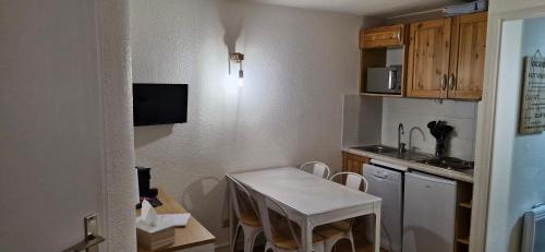 une petite cuisine avec une petite table et un évier dans l'établissement Appartement cosy au pied des pistes, à Morillon