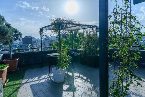 a balcony with plants and a pergola at Hotel Sunny in Batumi