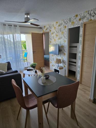 un salon avec une table, des chaises et un canapé dans l'établissement Appartement paisible à 300m de la plage, au Grau-du-Roi