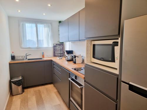 une cuisine avec un micro-ondes et un plan de travail dans l'établissement 3-4 pièces (65 m2) à Bois d’Arcy, à Bois-dʼArcy