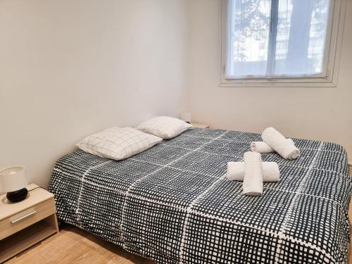 une chambre avec un lit avec deux serviettes blanches dessus dans l'établissement 3-4 pièces (65 m2) à Bois d’Arcy, à Bois-dʼArcy