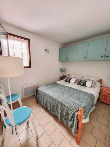 une chambre avec un lit et une chaise bleue dans l'établissement Appartement vue mer, à Cavalaire-sur-Mer