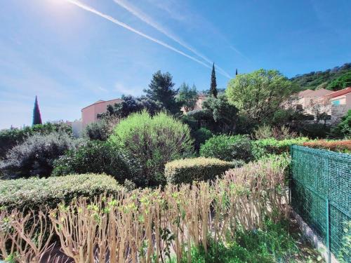un jardin avec des plantes et des arbres sur une colline dans l'établissement Appartement vue mer, à Cavalaire-sur-Mer