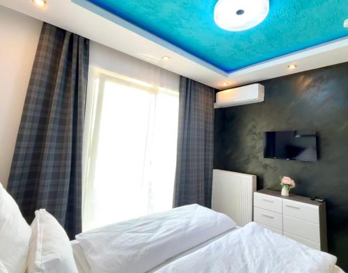 une chambre avec un lit avec un plafond bleu dans l'établissement City Stay Apartment - renoviert & klimatisiert, à Sarrebruck