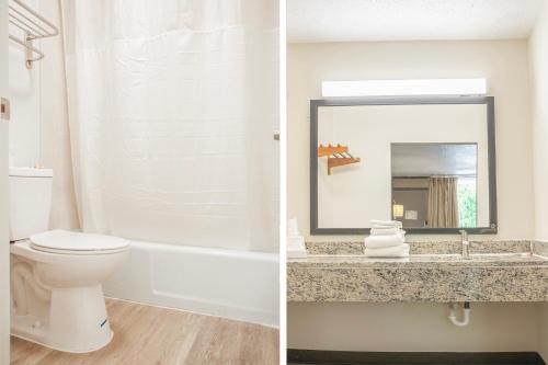 Un baño con inodoro, lavabo y espejo. en OYO hotel Greensboro east I 40, en Greensboro
