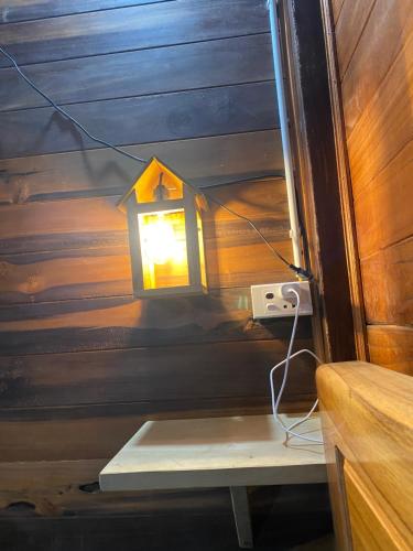 a light on the side of a room with a bench at Hà Giang Lake View House in Lan Hung