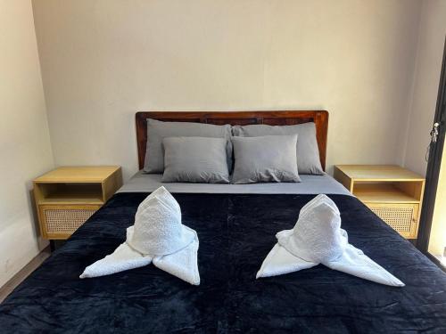 two white fish pillows on a bed with two tables at Coral Stay Bahia Drake in Drake