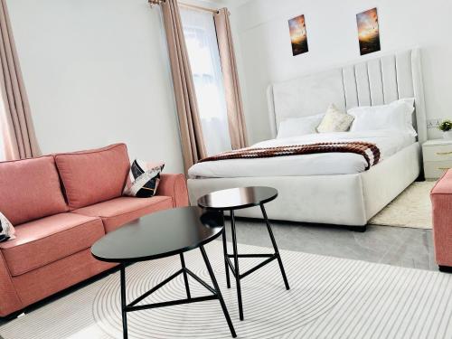 a living room with a bed and a table and a couch at Zen Studio for your Rest and Unwind in Nairobi
