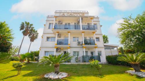 a white building with palm trees in front of it at La Cactus Boutique Hotel in Antalya