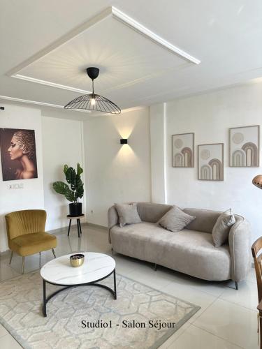 a living room with a couch and a table at Residence Life House Makepe bm in Douala