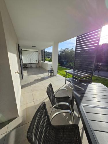 - un balcon avec deux chaises et une table sur une maison dans l'établissement Chez Paul et Corinne Appartement Propriano, à Propriano
