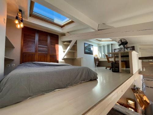 une chambre avec un lit et une lucarne dans l'établissement Superbe mini-duplex, à Paris