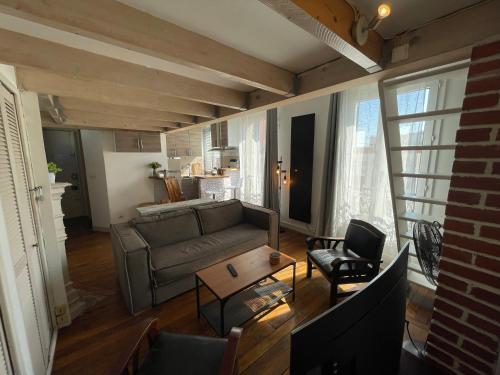 un salon avec un canapé et une table dans l'établissement Superbe mini-duplex, à Paris