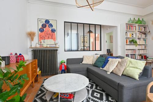 un salon avec un canapé et une table dans l'établissement Maison de ville familiale, bel extérieur, piscine !, à Nîmes