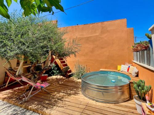 un bain à remous installé sur une terrasse à côté d'un bâtiment dans l'établissement Maison de ville familiale, bel extérieur, piscine !, à Nîmes