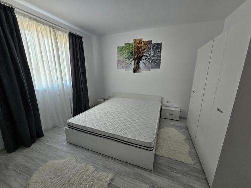 a small bedroom with a bed and a window at Apartament Residence in Călăraşi