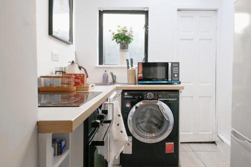 a kitchen with a washing machine under a counter at 2 Bedroom house 12 Rutland in Dublin