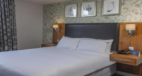 a bedroom with a large white bed and two pictures on the wall at Hull Humber View Hotel, BW Signature Collection in Hull