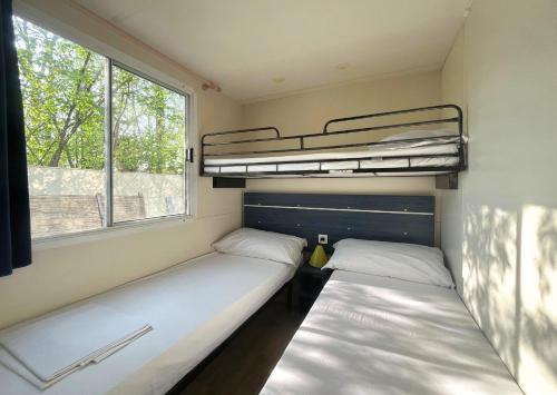twee bedden in een kleine kamer met een raam bij Del Falco AgriCamp-12 kilometers to Garda Lake and Verona in Bussolengo