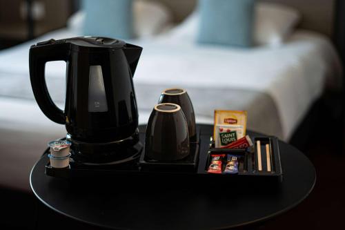 a coffee maker on a table next to a bed at Sure Hotel by Best Western Les Portes de Montauban in Montauban