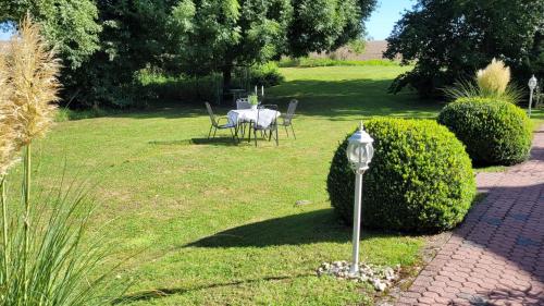 a garden with a table and chairs in the grass at Apartmenthaus Storchennest in Katzow