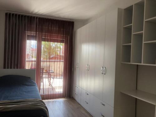 a bedroom with a bed and a sliding glass door at Comfort Apartment 3 in Ferizaj