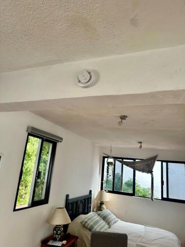 a bedroom with a bed and two windows at Beautiful Loft 10 minutes from AIFA in San Pedro Atzompa