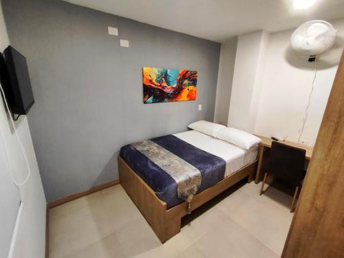 a bedroom with a bed and a painting on the wall at Apartment - 5 minutes from the airport in Pereira