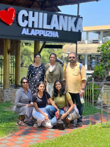 a group of people posing for a picture under a sign at Chilanka Lake View Resort in Alleppey