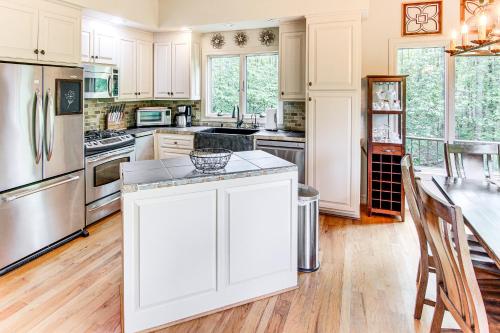 a kitchen with white cabinets and stainless steel appliances at Hot Tub and Trail Access Treehouse in Landrum! in Landrum