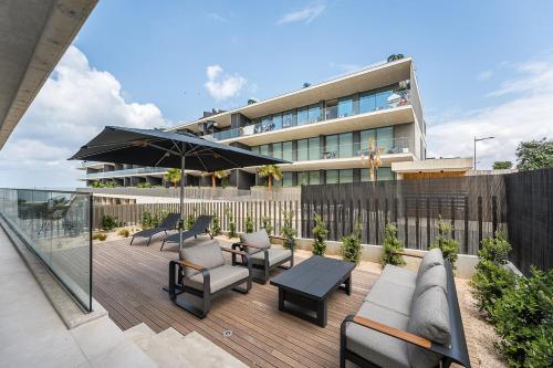 a patio with chairs and tables and a building at GuestReady - Bright & Inviting Stay in Vila Nova de Gaia